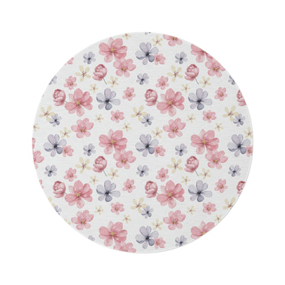 pink and purple flower pattern on a rug, flower pattern area rug sitting on a hardwood floor with a couch in front of a window, white rug with flower pattern
