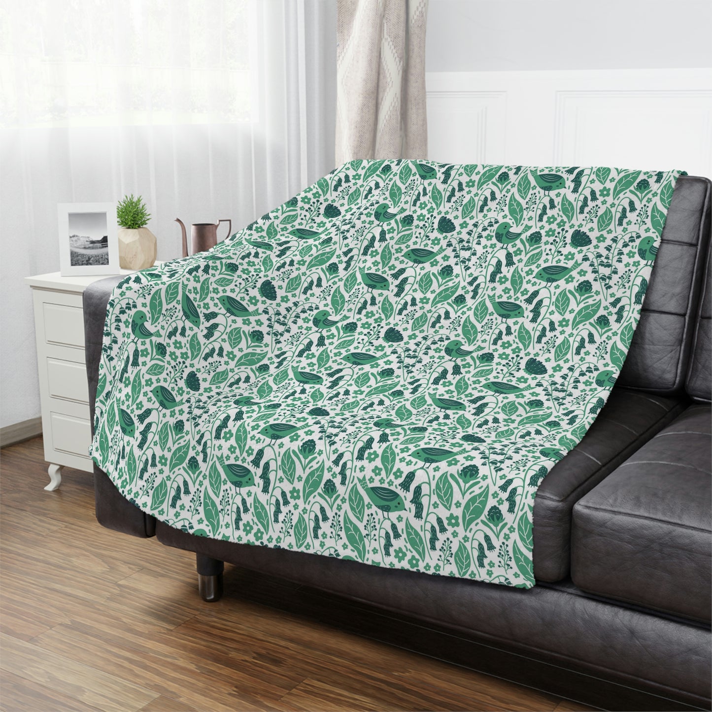 green plush throw blanket lying on a bed, floral bird blanket used in bedroom decor, green accent blanket for couch or bed