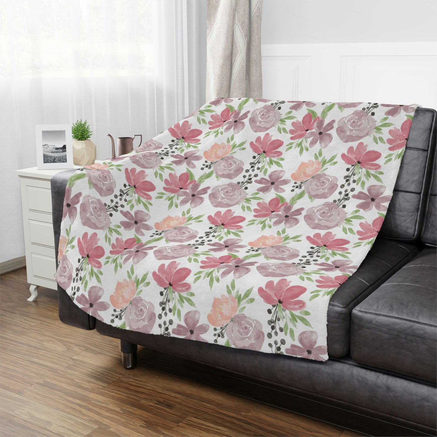pink and purple floral blanket on a couch, pink flower pattern on a blanket, purple floral throw blanket lying on a bed