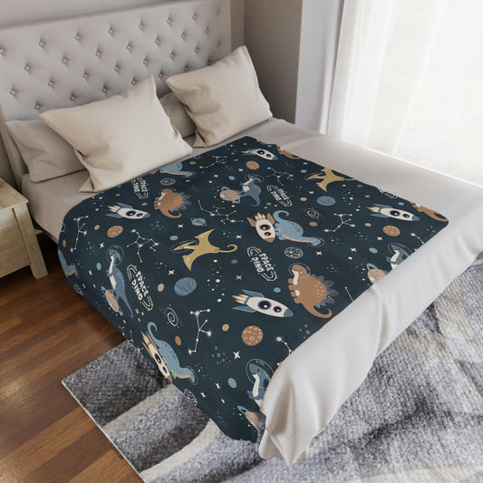 blue space theme baby blanket lying on a bed, space dinosaur nursery or playroom blanket lying on a bed, dinosaur throw blanket in a room