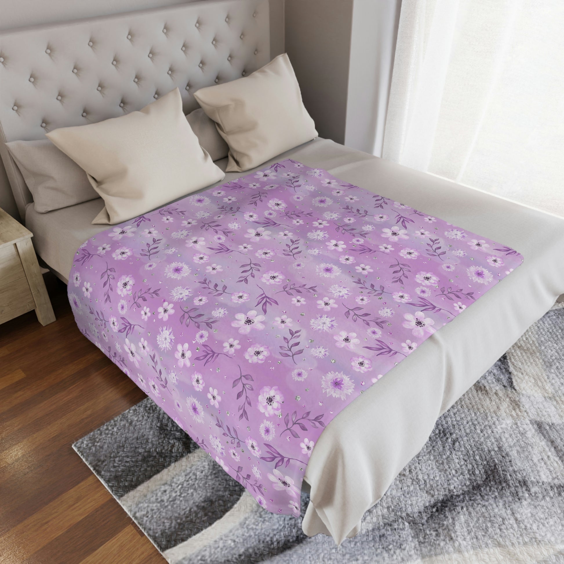 pink floral blanket lying on a bed, pink flowers on a throw blanket decorating a bedroom, pink floral plush blanket lying next to pillows on a bed