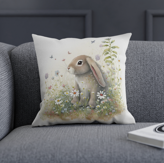 bunny accent throw pillow sitting on a grey couch, floral bunny pattern throw pillow decorating a sofa or arm chair, square bunny pillow decoration for spring