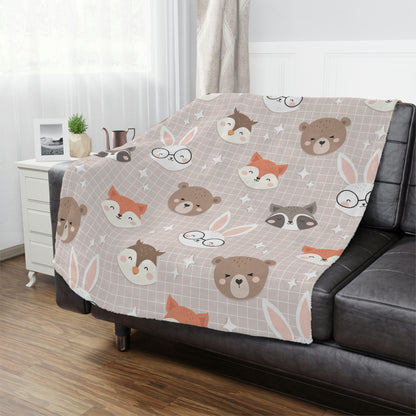 woodland animal throw blanket lying on a bed in a nursery or childs room, bear blanket on a chair, fox blanket on a couch, bunny blanket on a bed, owl blanket on a lounger, woodland theme nursery blanket on a crib