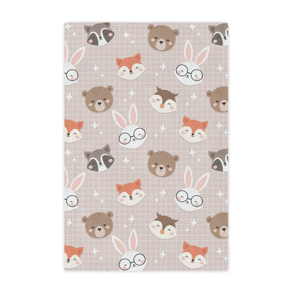 woodland animal throw blanket lying on a bed in a nursery or childs room, bear blanket on a chair, fox blanket on a couch, bunny blanket on a bed, owl blanket on a lounger, woodland theme nursery blanket on a crib