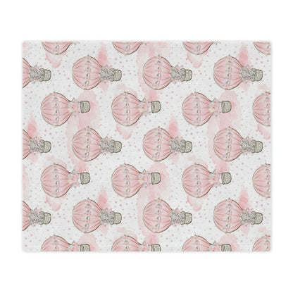 pink elephant in a hot air balloon baby blanket decorating a nursery, pink elephant throw blanket with hot air balloons on it lying on a bed, elephant nursery theme decor blanket accenting a nursery bed
