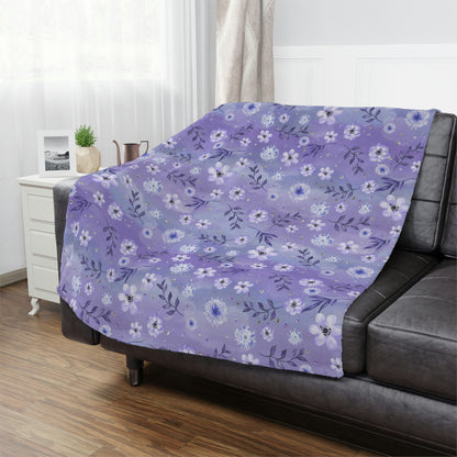 purple floral blanket lying on a bed, purple flowers on a throw blanket decorating a bedroom, purple floral plush blanket lying next to pillows on a bed